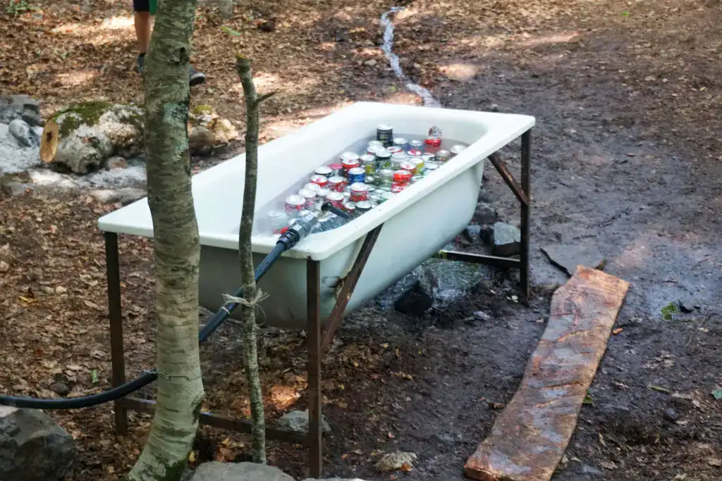 2. Verlassener Badsatz im Wald mit eingepackten Dosen als Kunstinstallation.